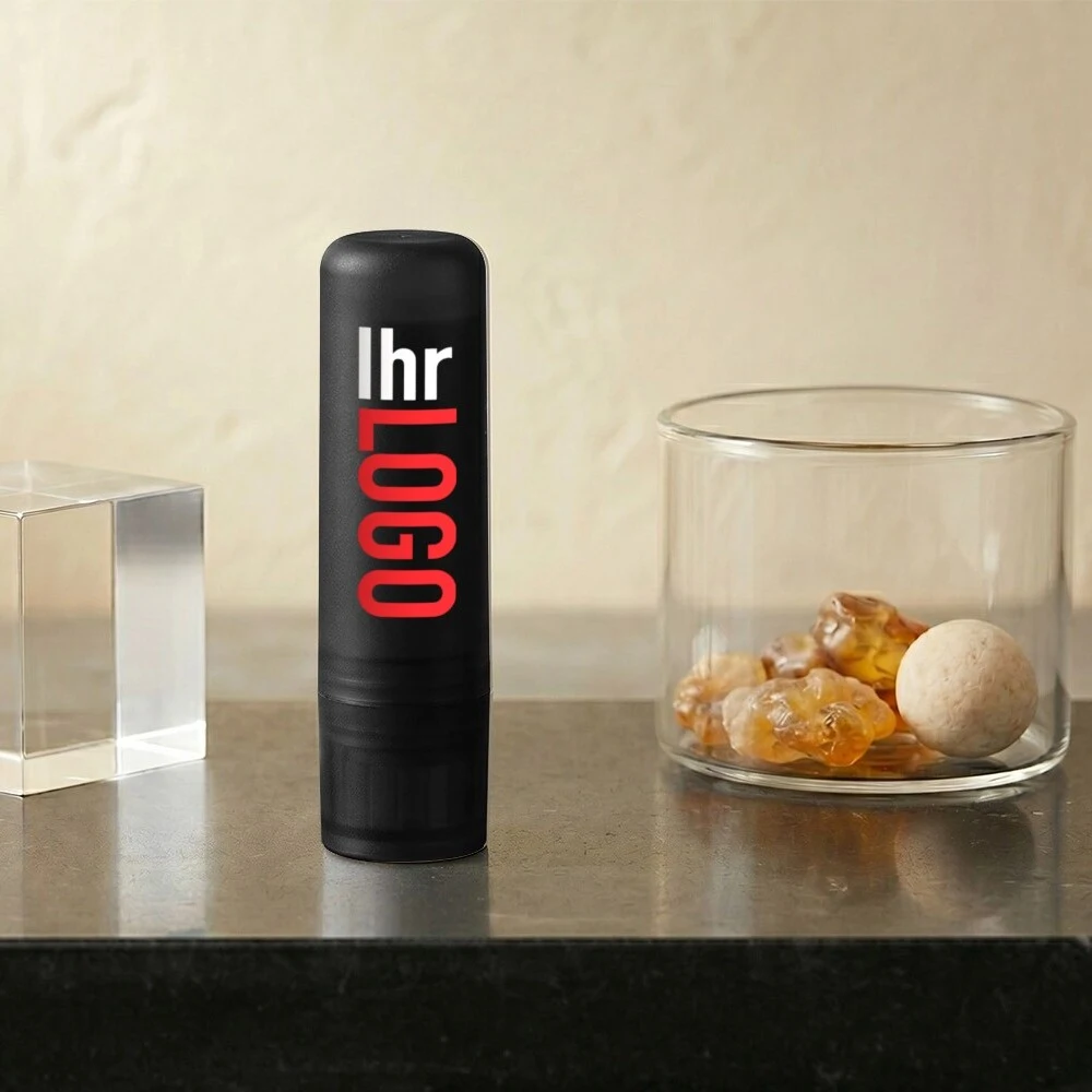 Deale Lippenpflegestift in Schwarz mit Logo auf dem Tisch – praktischer Werbeartikel für Unternehmen und Promotion