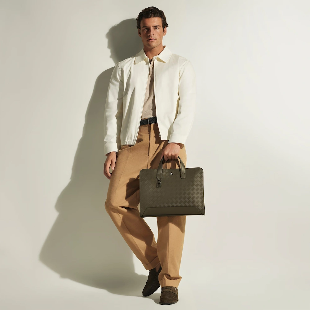 Montblanc Flache Schreibmappe aus Extreme Leder Montblanc Flache Schreibmappe aus Extreme Leder im Einsatz, stilvoller Mann hält die elegante Schreibmappe in der Hand, luxuriöses Business Accessoire für Meetings und Reisen, ideal als exklusives Geschenk.