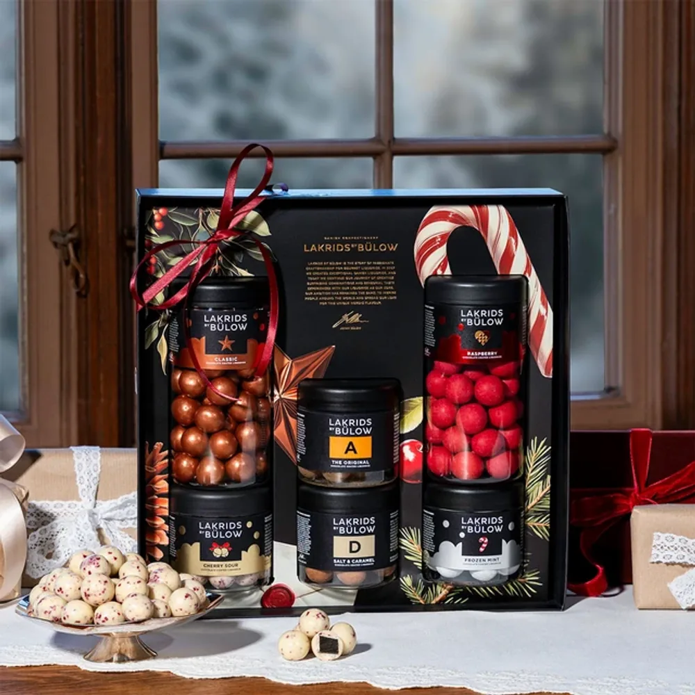 Large Black Box Winter Lakrids by Bülow, 1000 g Lakrids by Bülow Large Black Box Winter am verschneiten Fenster mit Zuckerstange – Firmengeschenk zu Weihnachten