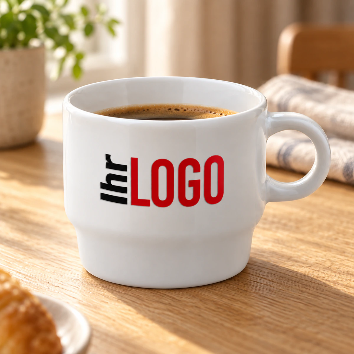 Tasse Satellite 180ml Weiße Tasse Satellite, 180 ml, mit Logo und Kaffee auf einem Holztisch beim Frühstück, neben Gebäck und Leinentuch.