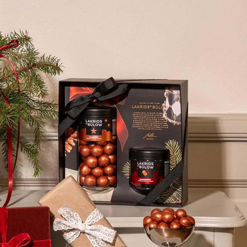 Lakrids by Bülow Black Box Classic & Raspberry mit Schleife auf Sideboard – Weihnachtsgeschenk für Kunden