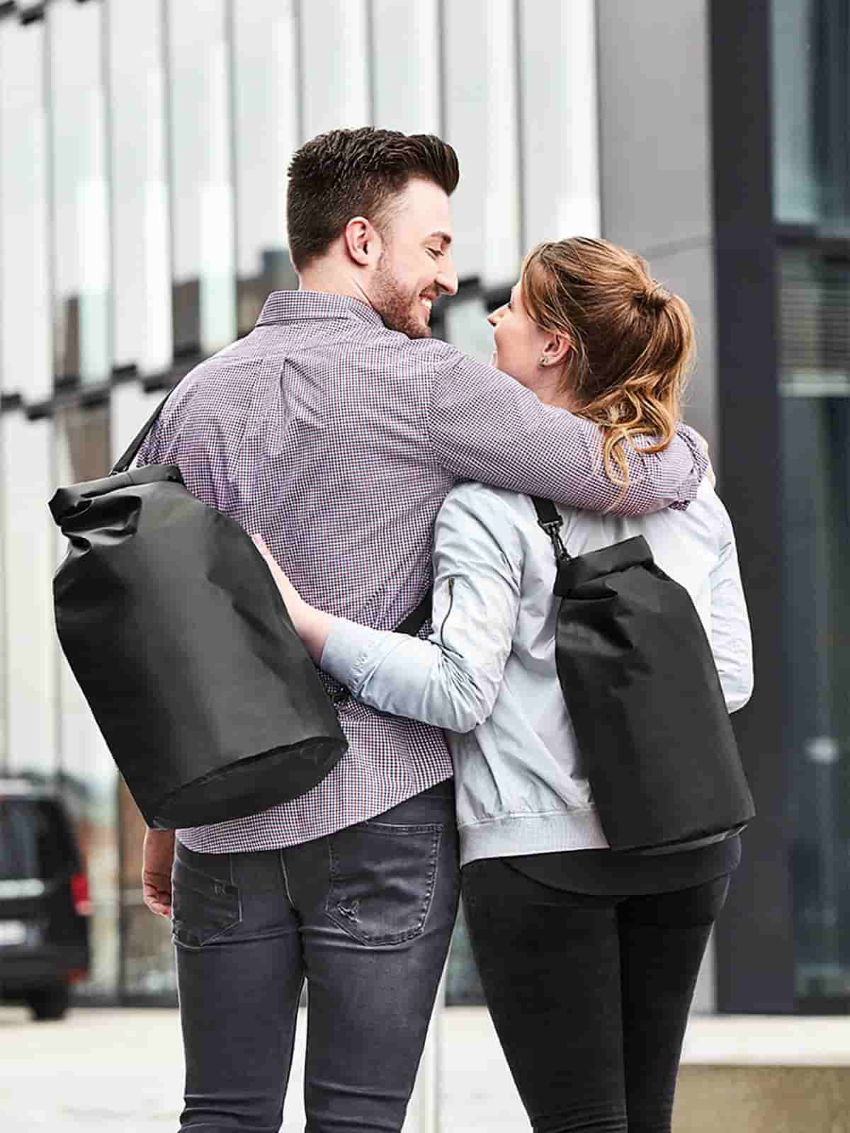 Frau und Mann mit Halfar Drybag SPLASH in Schwarz – praktische wasserdichte Tasche für Outdoor, Sport und Freizeit
