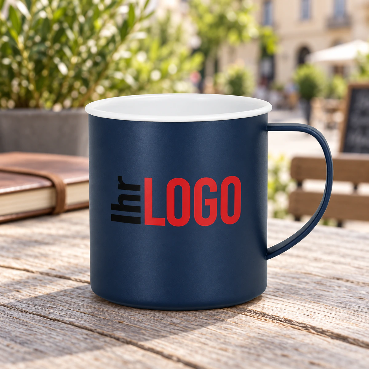 Tasse Mayfer, 300 ml Marineblaue Tasse Mayfer mit weißem Rand und Logoaufdruck auf einem Holztisch einer Caféterrasse als Werbetasse in Nahaufnahme.