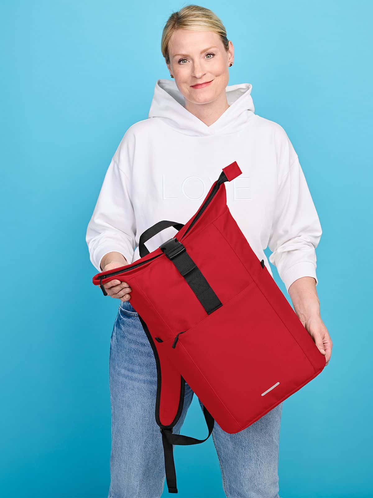 Frau mit Halfar Rucksack BASIC in Rot – auffälliger Werbeartikel Rucksack für Events, Freizeit und Promotion