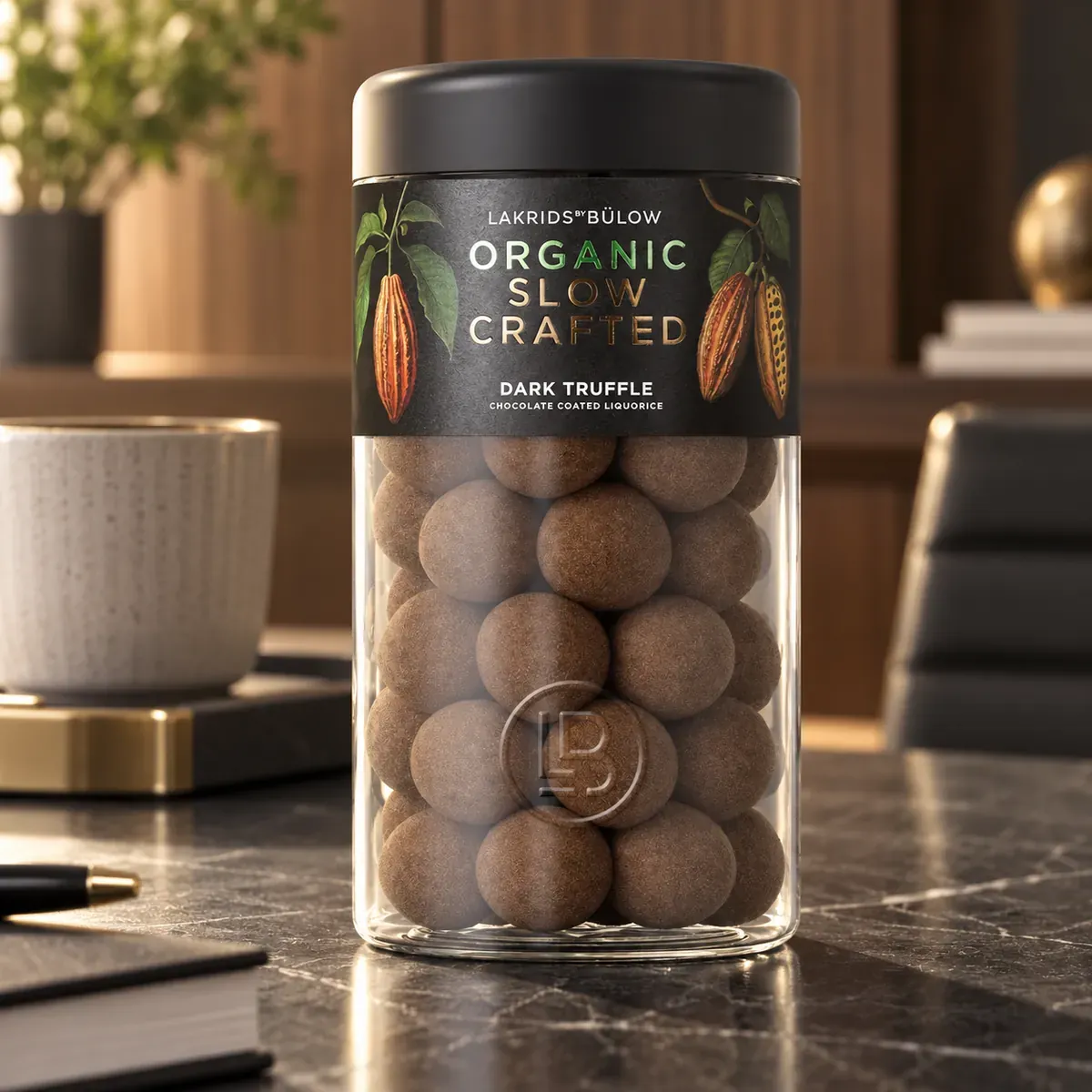 LAKRIDS BY BÜLOW Organic Slow Crafted Dark Truffle im Glas als edles Lakritz-Werbegeschenk auf einem Sideboard im Executive-Büro.