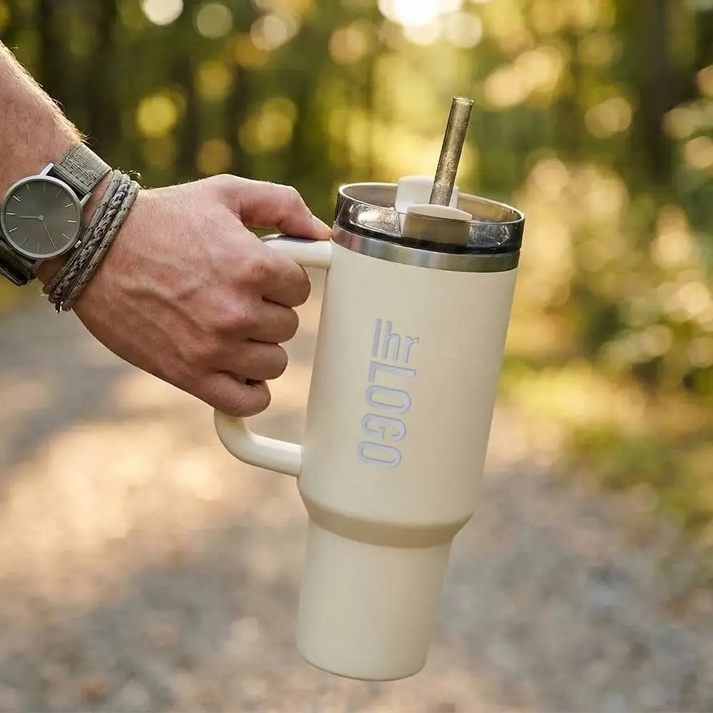 Stanley 1200 ml Quencher H2.0 Thermobecher Stanley Quencher Tumbler in Creme in Männerhand auf der Straße – moderner Werbeartikel für Alltag und Promotion