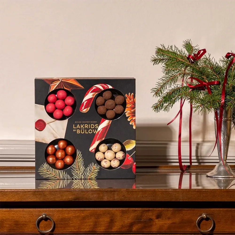 Lakrids by Bülow Small Winter Selection Box mit Zuckerstange auf Holzkommode – kleines Kundengeschenk