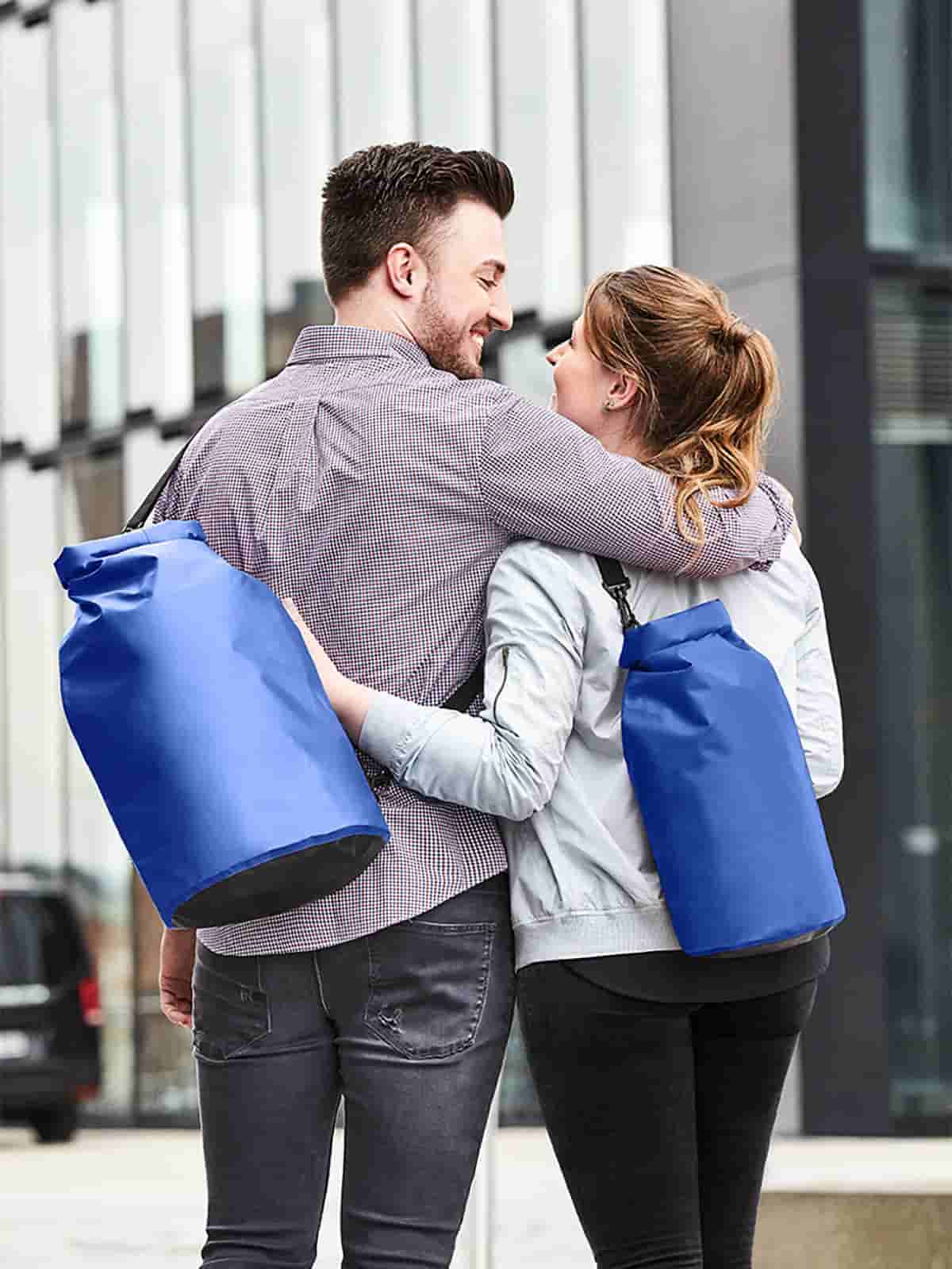 Frau und Mann mit Halfar Drybag SPLASH in Royalblau – wasserdichte Tasche für Outdoor, Sport und Freizeit