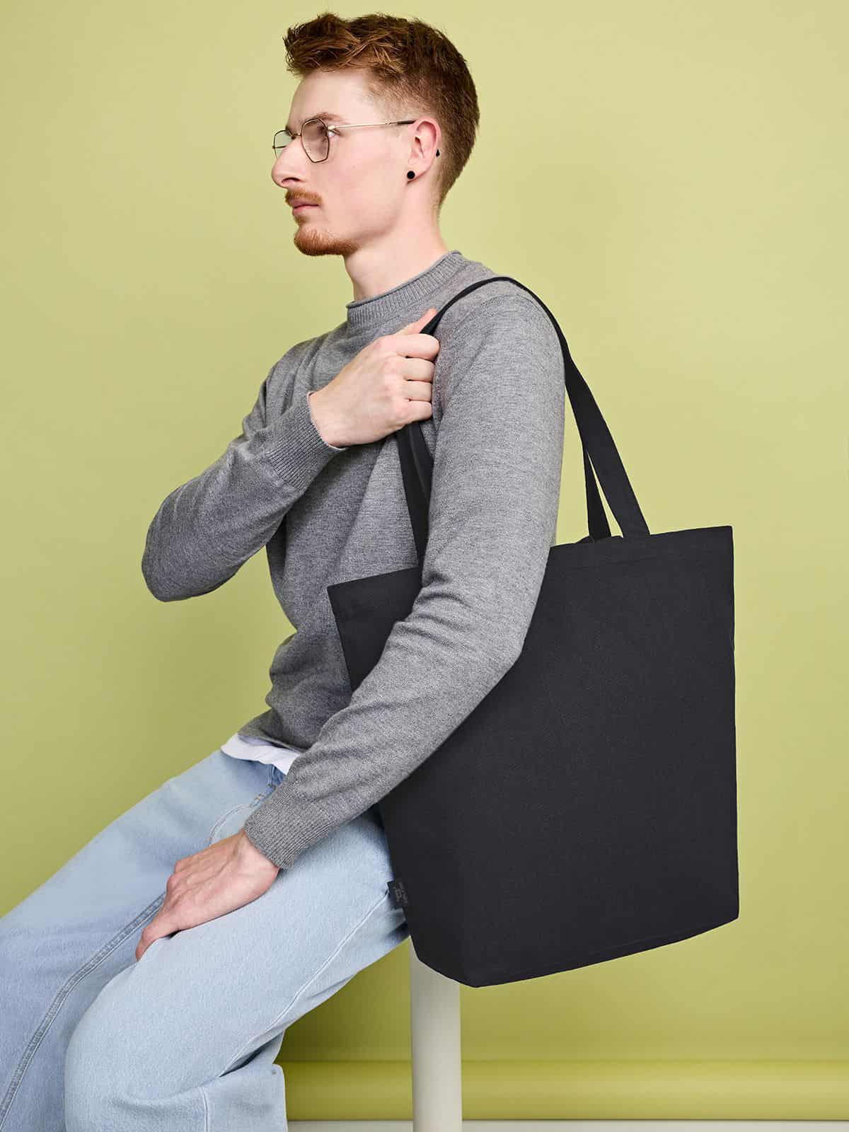 Mann mit Halfar Freizeit Shopper Organic in Schwarz – nachhaltige Werbetasche mit Logo für Alltag und Freizeit