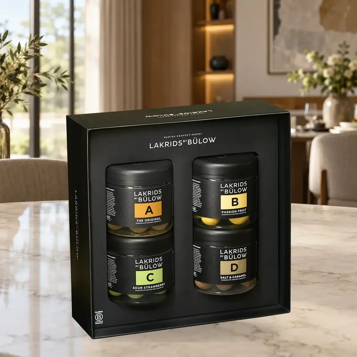 Geschenkbox Black Box A, B, C & D Lakrids by Bülow, 460 g LAKRIDS BY BÜLOW Black Box mit vier Small-Gläsern A, B, C und D als hochwertiges Lakritz-Geschenkset auf einem Marmortisch im Essbereich.