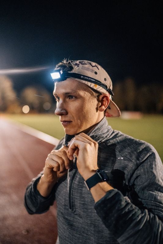 Ledlenser Stirnlampe NEO5R schwarz Läufer mit LEDLENSER NEO5R Stirnlampe auf der Laufbahn bei Nacht – Laufstirnlampe zum Bedrucken