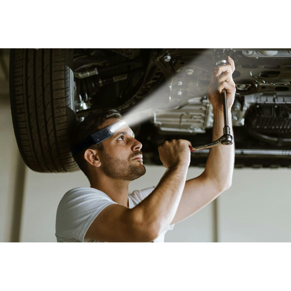Product image Mechaniker mit NIMBUS Stirnleuchte arbeitet unter einem Auto – Stirnleuchte mit Sensor zum Bedrucken