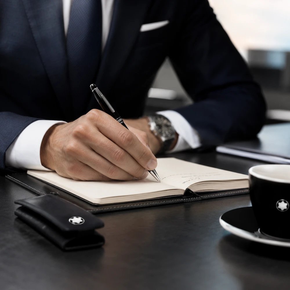 Montblanc Meisterstück Classique Kugelschreiber Platin (BP 164) in der Hand eines stilvollen Geschäftsmanns – luxuriöses Schreibgerät für Business